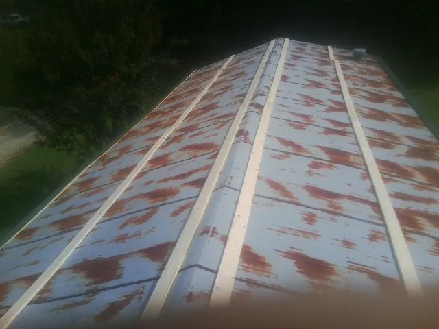 Rusted metal roof panels with new wood purlins before replacement — Storm Damage Roof Repair in Westphalia by Roofing Brothers