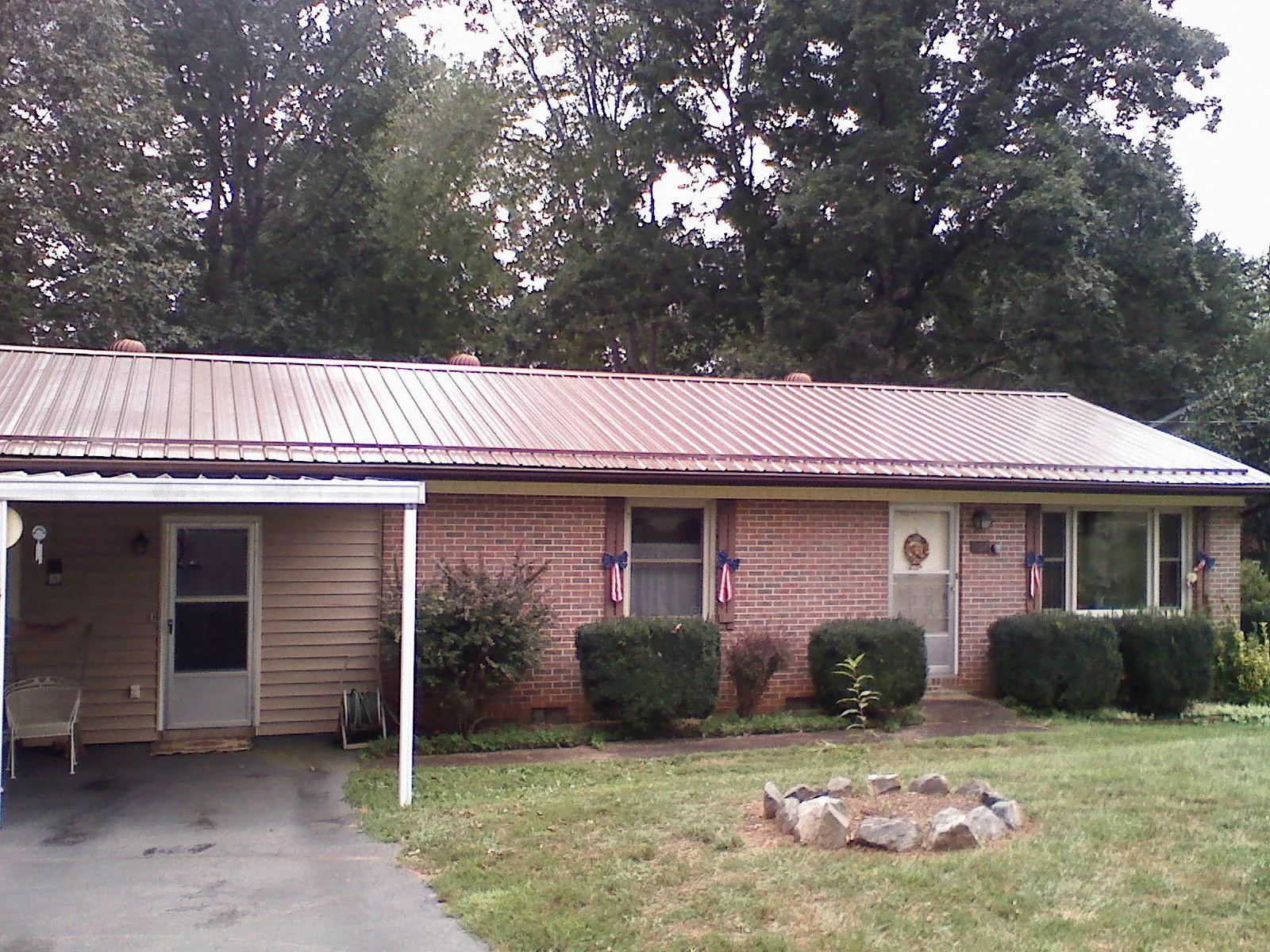 Bronze metal roof and carport on a brick ranch home — Roof Repair work by our crew in Westphalia