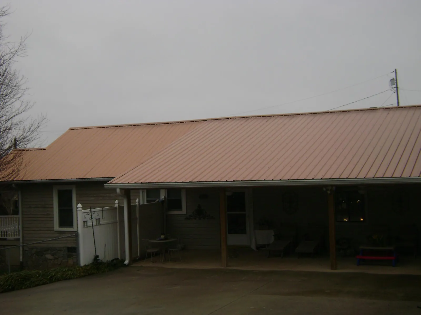 Copper toned metal roof over a wide covered patio in Westphalia